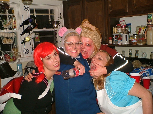 Four women in Halloween costumes posing for the camera. 