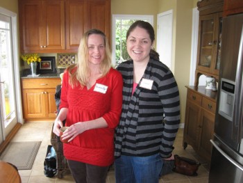 Two women posing in a kitchen. 