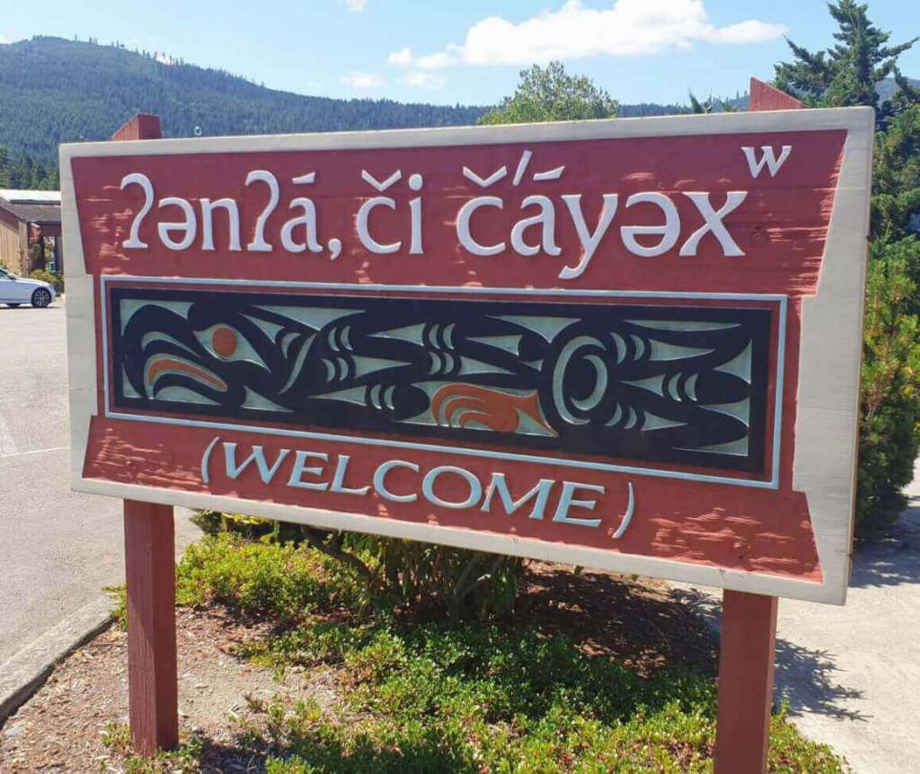A welcome sign carved in both English and S'Klallam. An eagle carved in traditional Pacific Northwest Native tribal art.
