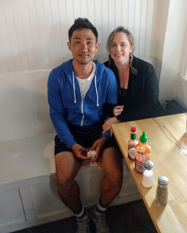 A couple posing in a restaurant booth at Overeasy breakfast spot in Kailua, Hawai'i.