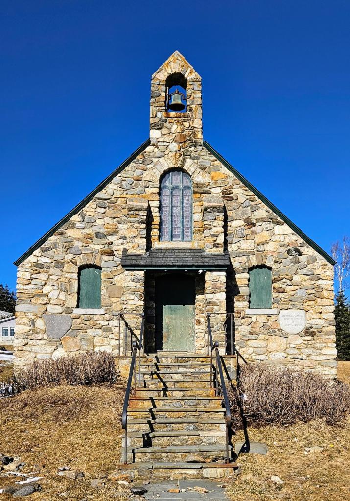 A chapel with a small bell tower and copper bell made from stones and rocks.