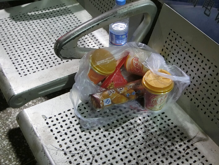 A bag of Chinese snacks on a chair in the Zhengzhou train station.