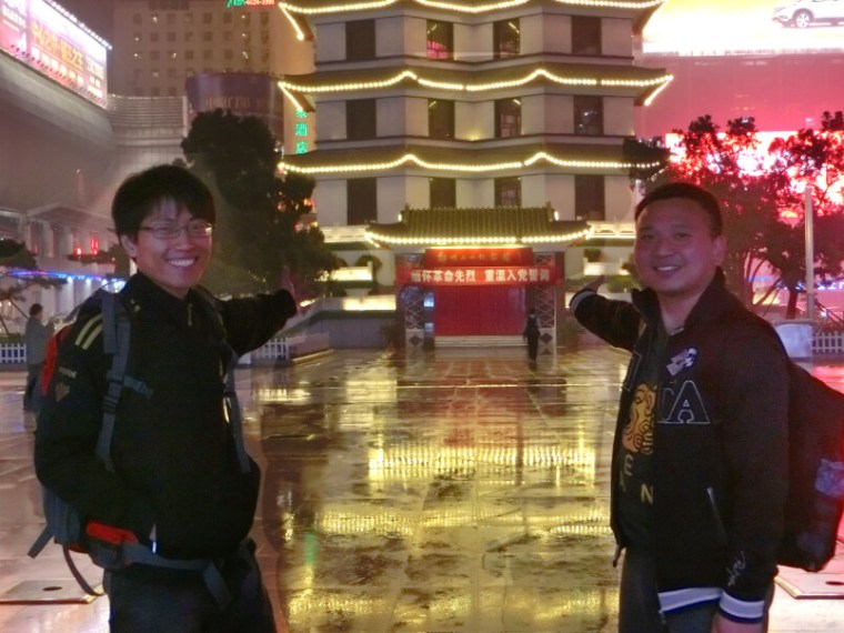 Two friends in China posing in front of Erqi Tower in Zhengzhou.